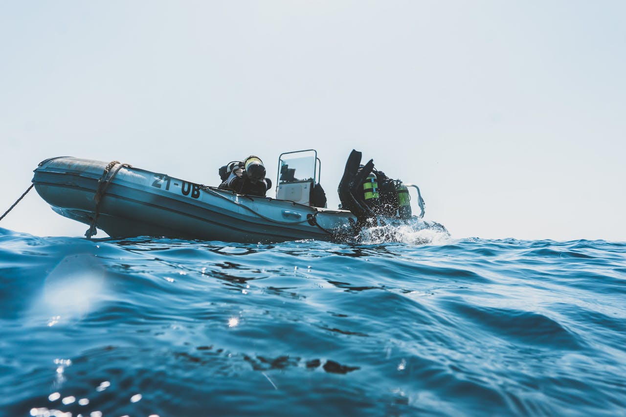 gallery-05 Scuba divers equipped for an ocean dive prepare from an inflatable boat on a sunny day.